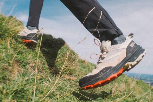 Zomerse opname van twee wandelaars met wandelrugzakken in een sportieve look van achteren