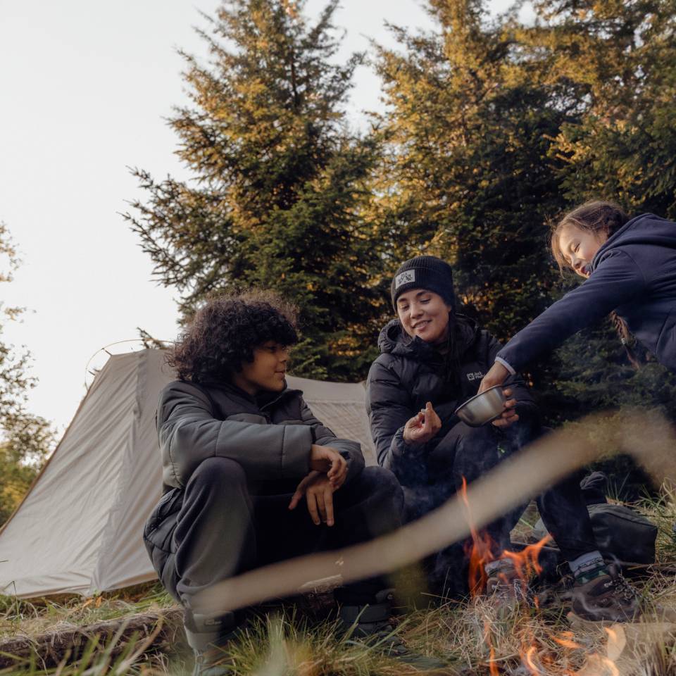 Trois jeunes randonneurs assis ensemble dans un décor forestier automnal