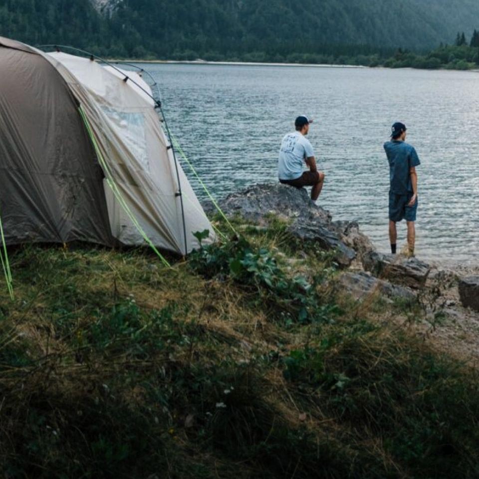 Twee personen liggen in een tent en vormen met hun handen samen een hart